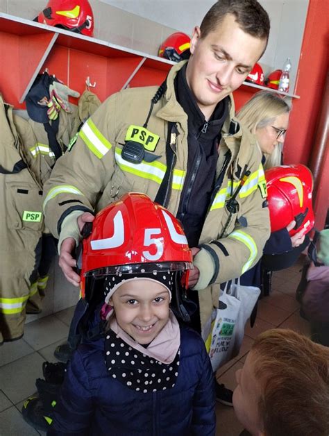 Ilustracja przedstawiająca Wojtka w strażackim hełmie podczas uroczystości przyjęcia do straży pożarnej