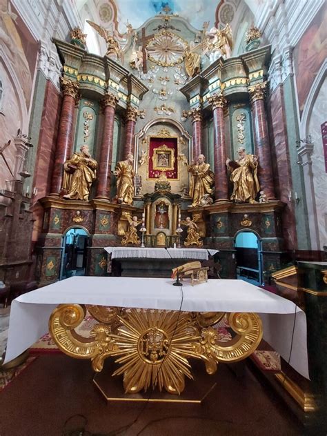 Wnętrze kościoła w Izdebnie Kościelnym z widokiem na ołtarz główny i zabytkowe rzeźby.