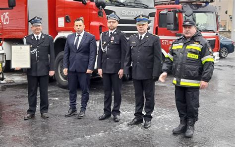 Zdjęcie przedstawiające oficjalne przekazanie decyzji o włączeniu OSP do KSRG, z udziałem przedstawicieli straży pożarnej i lokalnych władz