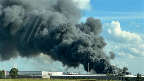Tematyczne zdjęcie płonącej hali w Złocieńcu, z widocznym dymem i strażakami w akcji
