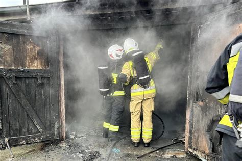 Strażacy gaszący pożar samochodów w garażu