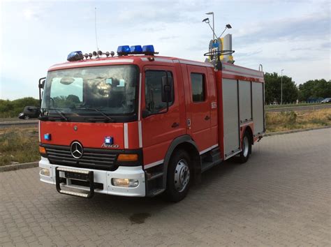 Zgromadzeni mieszkańcy Praszki witający nowy wóz strażacki Mercedes Atego w asyście policji