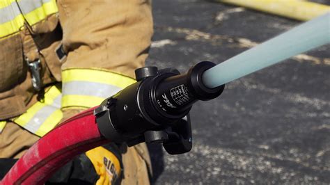 Photo of a firefighter holding a firefighting nozzle (prądownica)