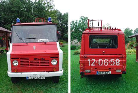 Fotografia starego wozu strażackiego Żuk na tle remizy OSP