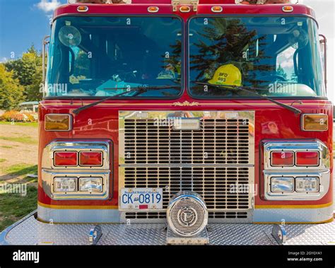 Photo of a fire truck in front of a fire station with flags at half-mast