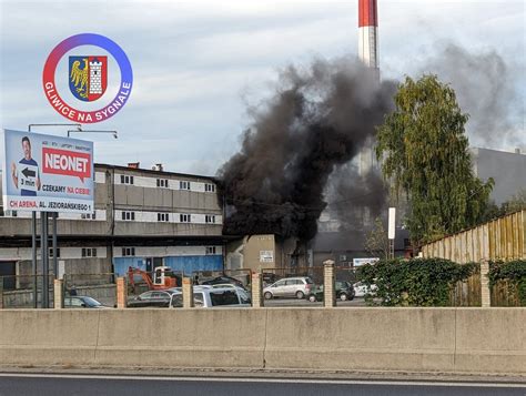 zdjęcie płonącej dawnej fabryki drutu w Gliwicach, kłęby dymu widoczne nad miastem