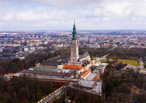 Jasna Góra w ogniu - płonąca wieża klasztorna podczas pożaru w 1900 roku, w tle sylwetki modlących się pielgrzymów