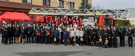 Grupa gości i członków OSP pozująca do wspólnego zdjęcia podczas zebrania