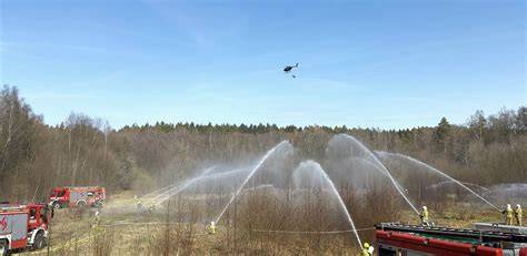 Zdjęcie strażaków walczących z pożarem lasu przy wsparciu helikoptera