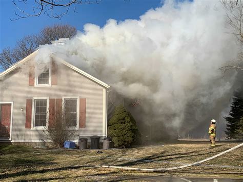 Thematic photo of a house destroyed by fire, showing smoke and rubble