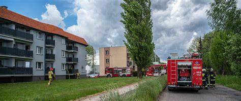 Strażacy gaszący pożar mieszkania w budynku wielorodzinnym