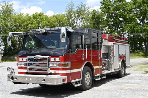 Photo of new fire trucks with firefighters and local officials