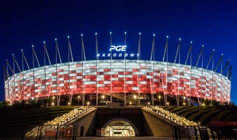 zdjęcie PGE Narodowego nocą z widocznymi światłami służb ratunkowych