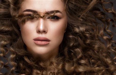 Fryzjer przypalający włosy modelce zapalniczką w studio telewizyjnym