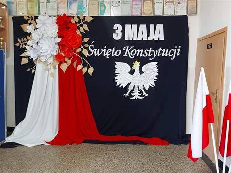 Zdjęcie przedstawiające uczniów podczas uroczystości szkolnej lub scenę z obchodów Święta 3 Maja