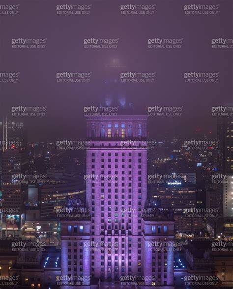 The Palace of Culture and Science at night, with fog and red lighting, resembling smoke