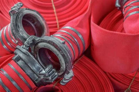 strażacy używający węży pożarniczych i prądownic