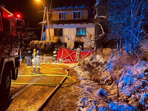 Strażacy wynoszący osobę poszkodowaną z płonącego budynku