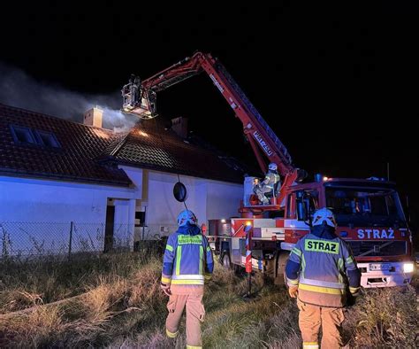 akcja gaśnicza domu jednorodzinnego w nocy, strażacy z wężami