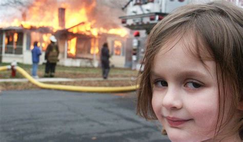 Zdjęcie Zoe Roth (Disaster Girl) na tle kontrolowanego pożaru budynku