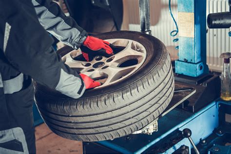 Zdjęcie przedstawiające mechanika sprawdzającego oponę w warsztacie wulkanizacyjnym