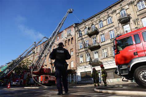 Zdjęcie strażaków pracujących na miejscu pożaru kamienicy