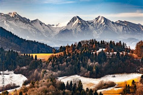 Tematyczne zdjęcie wsi Pstroszyce, ukazujące pagórkowaty krajobraz i daleki widok na Tatry, jeśli możliwe