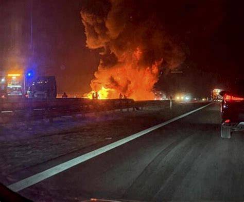 Zdjęcie przedstawiające pożar naczepy samochodu ciężarowego na autostradzie.