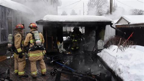 Thematic photo of a burning garden shed with firefighters in the background