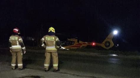 Dwóch strażaków (kobieta i mężczyzna) rozmawiających z poszkodowanym w samochodzie