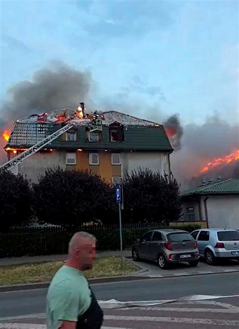 Widok płonącego budynku mieszkalnego z widocznymi dymem i płomieniami