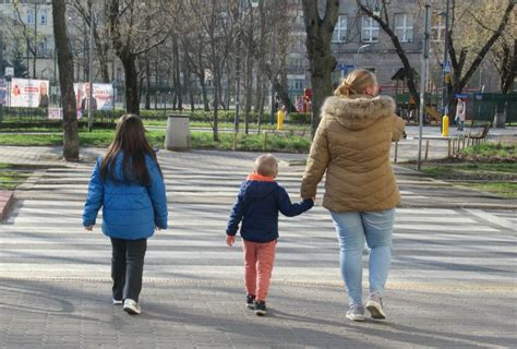 Pieszy z elementami odblaskowymi w warunkach słabej widoczności, kontrastujący z ciemnym otoczeniem, symbolizujący bezpieczeństwo na drodze