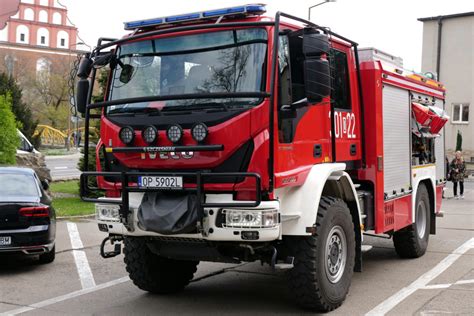 Zdjęcie przedstawiające wozy straży pożarnej i dym wydobywający się z domu jednorodzinnego