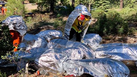 Illustration of a fire shelter (fire retardant tent) deployed by a firefighter