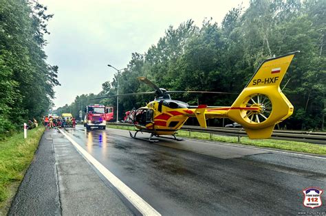 Służby ratownicze przy płonącej cysternie, zaporami na rzece