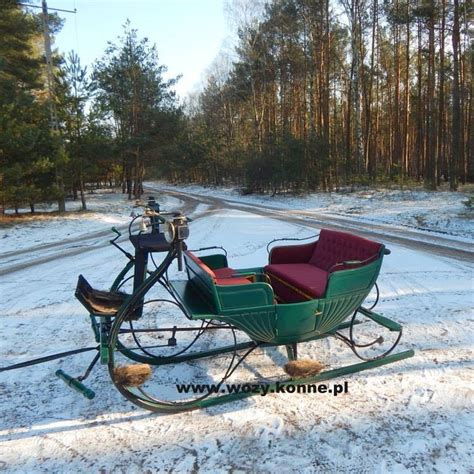 Zdjęcie przedstawiające historyczny sprzęt strażacki, np. sikawkę ręczną i wozy konne.