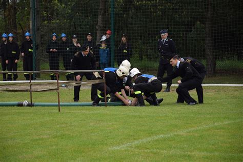 Zdjęcie z zawodów sportowo-pożarniczych, pokazujące uczestników podczas konkurencji.