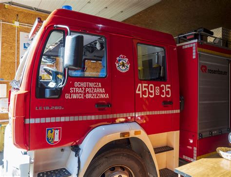 Zdjęcie przedstawiające zgliszcza po pożarze i pracujących strażaków ochotników