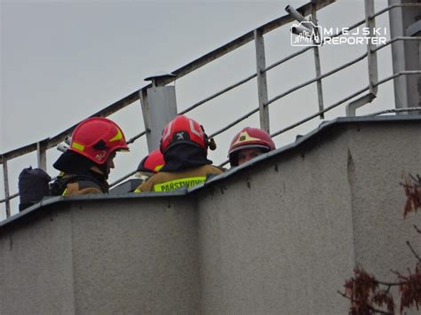 zdjęcie strażaków walczących z ogniem na dachu bloku
