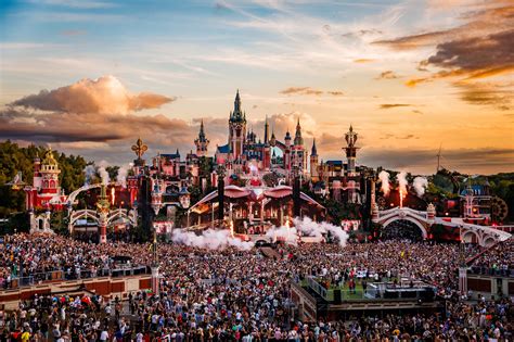 Panoramiczne ujęcie festiwalu Tomorrowland z widocznym tłumem i licznymi scenami