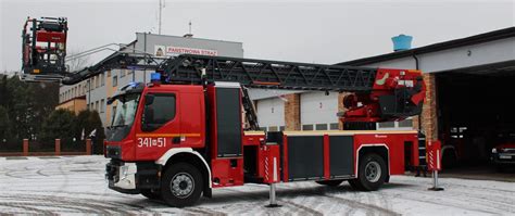 pojazd straży pożarnej z drabiną mechaniczną przy bloku