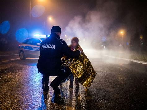 Policjanci gaszący pożar samochodu w Augustowie wężem ogrodowym