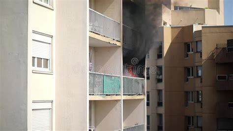 Photo of a residential building at night with smoke emanating from a window on the top floor