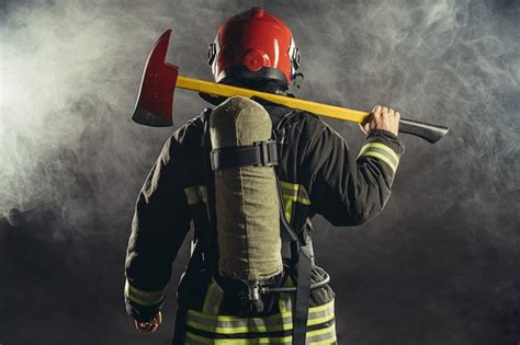 Strażak w rękawicach izolujących trzymający narzędzia ratownicze
