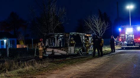 Zdjęcie przyczepy kempingowej po pożarze, teren zabezpieczony przez służby