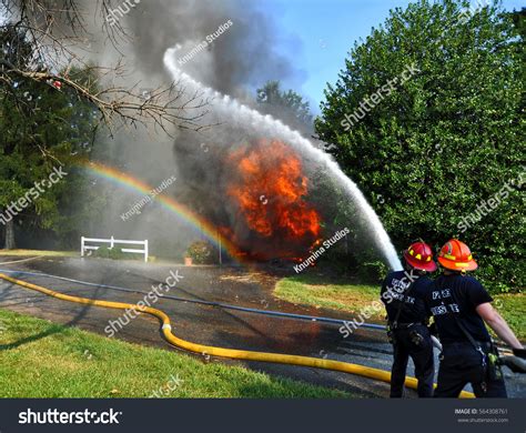 Thematic photo of firefighters in action during a competition, e.g., connecting hoses or putting out a simulated fire.