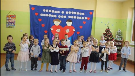 Zdjęcie z występów dzieci dla dziadków: wnuczęta w odświętnych strojach podczas recytacji wierszy i śpiewania piosenek.