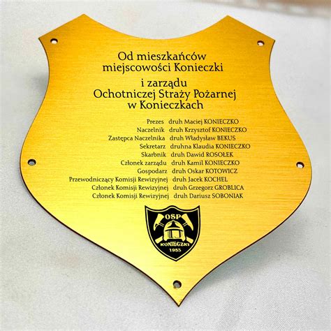 zdjęcie druha wbijającego gwóźdź w pamiątkową tablicę