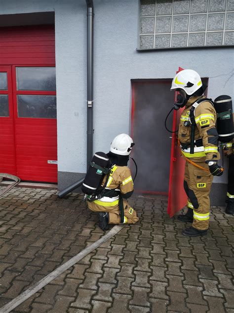 strażacy w aparatach ochrony dróg oddechowych wchodzący do zadymionego budynku