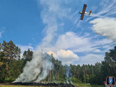 Samolot gaśniczy dokonujący zrzutu wody nad płonącym lasem